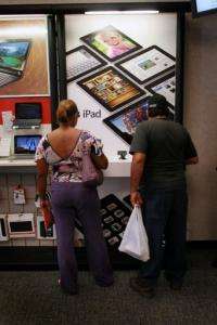 Customers check out the iPads on display at a store in Coral Gables, Florida