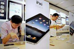 Customers look at iPads at the Apple store in Shanghai