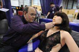 Engineer-inventor Douglas Hines adjusts the head of his company's "True Companion" sex robot, Roxxxy