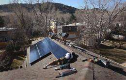 Installers for Namaste Solar connect solar panels to the roof of a home