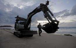 Israeli police explosives experts use a bomb disposal robot to scan the beach