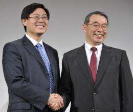 Lenovo CEO Yang Yuanqing (L) shakes hands with NEC president Nobuhiro Endo