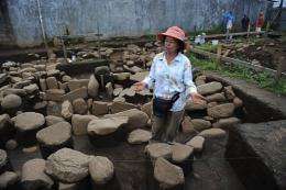 Maritza Gutierrez works on tombs made with stones at an indigenous cemetery