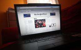 NYTimes.com website is displayed on a laptop
