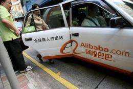 Passengers take a taxi adourned with the logo of e-commerce firm Alibaba in Hong Kong