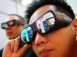People watch a 3D TV set using special googles at the CeBit 2010 fair in Hanover