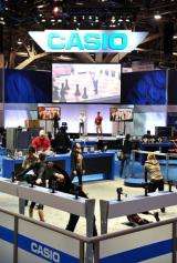 Performers stretch at the Casio display before the opening of the 2010 International Consumer Electronics Show
