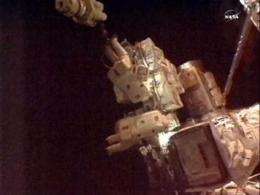 Spacewalking astronauts plug in new cooling pump (AP)