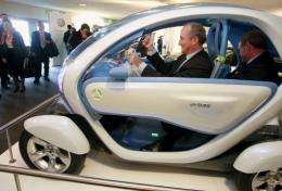 Spanish Minister of industry Miguel Sebastian (C) sits in an electric car with Jean Pierre Laurent