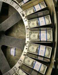 Stacks of one dollar bills pass through a machine at the Bureau of Engraving and Printing in Washington, DC