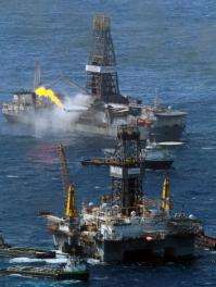 The Transocean Development Driller III (R) and the Discoverer Enterprise drilling rig continue the effort to recover oil