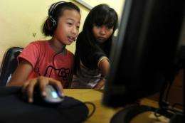 Two Indonesian girls surf the web an Internet shop in Jakarta