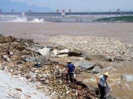 Two workers clean up trash along the bank of the Yangtze River