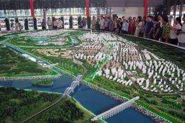 Visitors look at a model of an "eco-city"