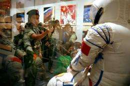 Visitors take photos during an exhibition on "China's First Spacewalk Mission" at the Hong Kong Science Museum