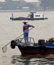 Workers clear waste from the heavily polluted Pearl River in southern China's Guangdong province
