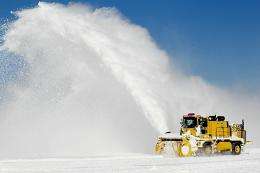 Workers remove snow from a runway at O'Hare International Airport on February 3