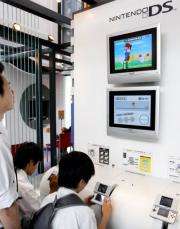 Young boys play Japanese video game giant Nintendo's portable video game console "Nintendo DS"